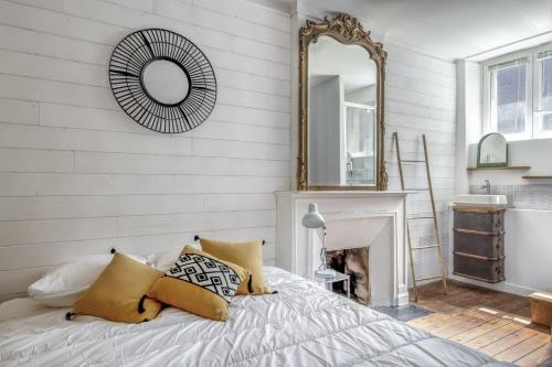 - une chambre avec un lit avec un miroir et une cheminée dans l'établissement BOURSE - Appart ambiance bohème chic à Nantes, à Nantes
