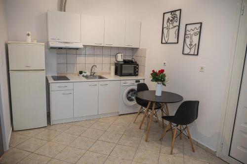 a kitchen with a table and a sink and a refrigerator at Happy Room-2' from sea in Kalamata