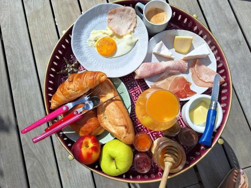 a plate of breakfast food on a wooden table at TINY HOUSE avec piscine "La Bernadette" villa Sisyphe in Le Thoronet