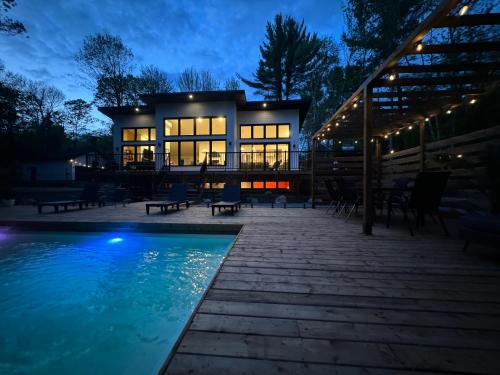 une maison avec piscine la nuit dans l'établissement Le Singapour - Cottage Resort - Brownsburg-Chatham, à Brownsburg