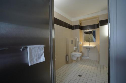 a bathroom with a toilet and a sink at Anaïs Hôtel Bourges Nord Saint-Doulchard in Bourges