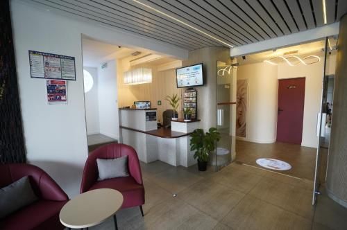 a waiting room with a table and chairs at Anaïs Hôtel Bourges Nord Saint-Doulchard in Bourges