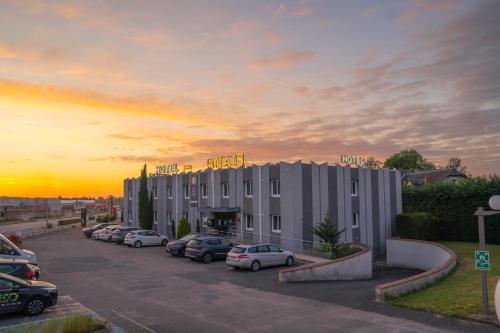 a building with cars parked in a parking lot at Anaïs Hôtel Bourges Nord Saint-Doulchard in Bourges