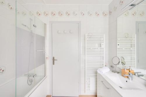 une salle de bain blanche avec une baignoire et un lavabo dans l'établissement Belle maison pour 7 à 300m de la plage au Guilvinec, au Guilvinec