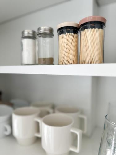 a shelf with cups and mason jars and chopsticks at Im home in Perea