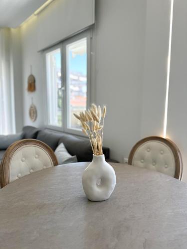 a white vase sitting on top of a table at Im home in Perea