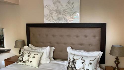 a bedroom with a bed with white sheets and pillows at TeBeacon Accommodation in East London