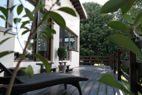 a wooden deck with a table and a potted plant at LIPA houses & spa in Sopot