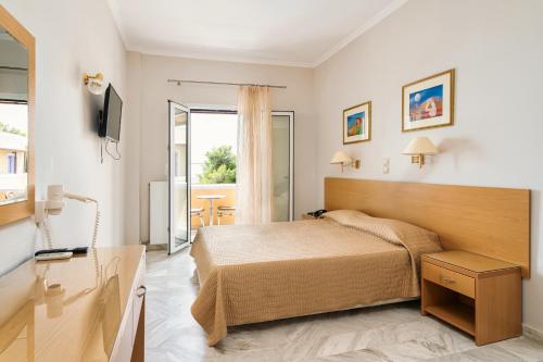 um quarto de hotel com uma cama e uma televisão em Katerina Hotel em Agia Marina Aegina