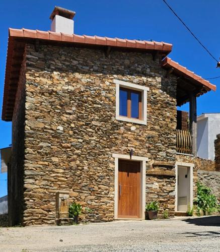 a stone house with a door and a window at Casinha da Fonte in Lamas de Podence