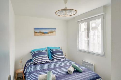 a bedroom with a bed with blue and white stripes at À 300m de la Greve Blanche - Appartement pour 6 in Le Guilvinec