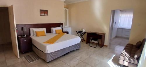 ein Schlafzimmer mit einem großen weißen Bett mit gelben Kissen in der Unterkunft Thokgamo Bed and Breakfast in Kanye