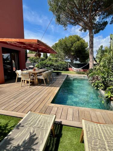 une arrière-cour avec une terrasse en bois et une piscine dans l'établissement Villa Uvéa, à Saint-Aygulf