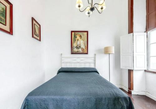 ein Schlafzimmer mit einem Bett mit einer blauen Decke in der Unterkunft 3 bedrooms house with wifi at Santa Cruz de la Palma in Santa Cruz de la Palma