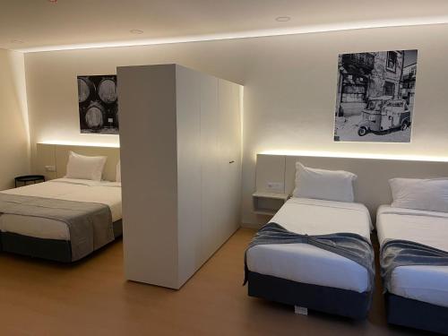 een hotelkamer met 2 bedden en een kast bij Areosa in Porto