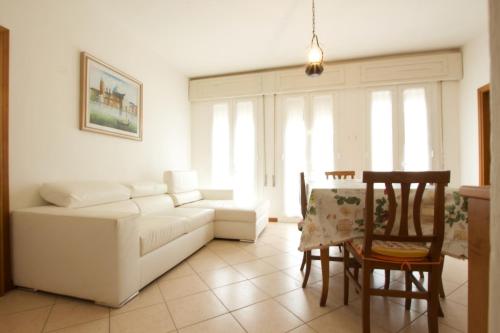 - un salon avec un canapé blanc et une table dans l'établissement 12 Accesso - Home Immobiliare Jesolo, à Lido di Jesolo