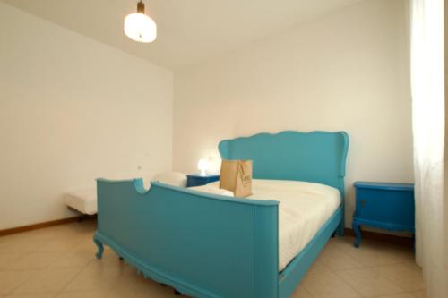 - un lit bleu dans une chambre avec un cadre bleu dans l'établissement 12 Accesso - Home Immobiliare Jesolo, à Lido di Jesolo