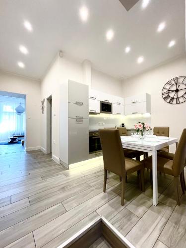 a kitchen and dining room with a table and chairs at Trigon Palace in Budapest