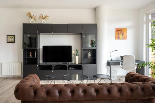 a living room with a couch and a television at Charme de Bollwiller in Bollwiller