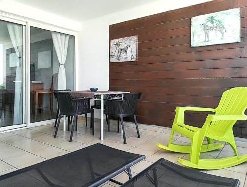um pátio com uma mesa e cadeiras num quarto em Appartement de 2 chambres a Saint Pierre a 600 m de la plage avec vue sur la mer piscine partagee et terrasse amenagee em Saint-Pierre