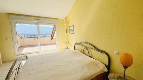 a bedroom with a bed and a window at Appartement SANTA REGINA 3 Calvi in Calvi