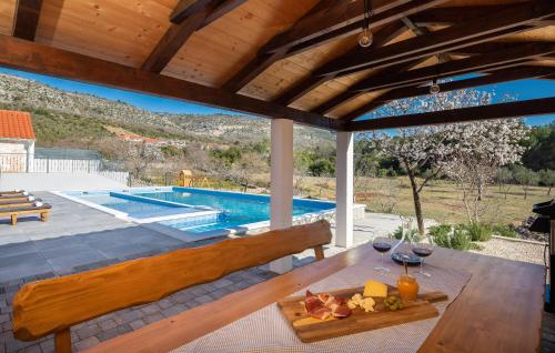 a patio with a table and a swimming pool at Lovely Home In Dubrava Kod Sibenika in Protega