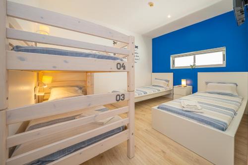 2 łóżka piętrowe w pokoju z niebieskimi ścianami w obiekcie Hostel Supremo w Armação de Pêra