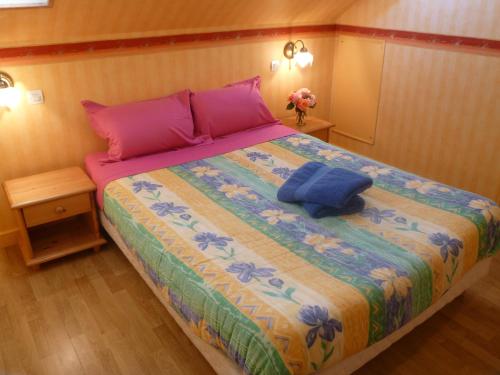ein Schlafzimmer mit einem großen Bett mit rosa und blauen Kissen in der Unterkunft Family DELCOUR in Mailly-Maillet