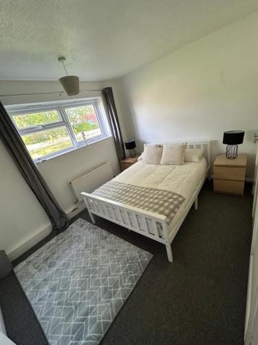 a small bedroom with a bed and a window at DK House in Colchester