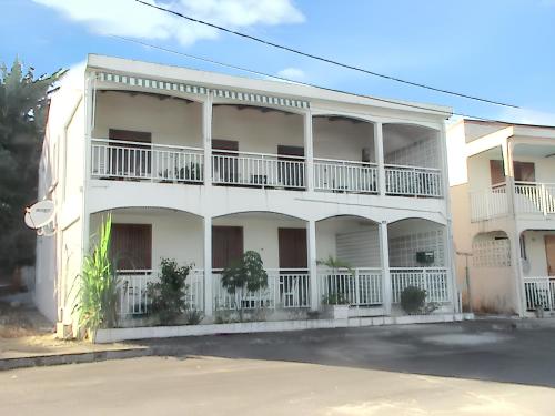 un edificio bianco con balconi e una strada di Maison de 2 chambres avec vue sur la mer terrasse amenagee et wifi a Petit Bourg a 3 km de la plage a Petit-Bourg