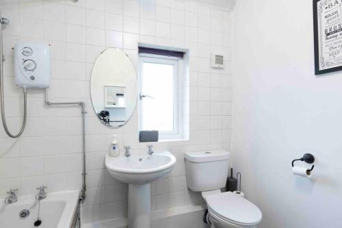 a bathroom with a sink toilet and a mirror at 3 Bedroom Large House, Near Leeds City, Parking in Killingbeck