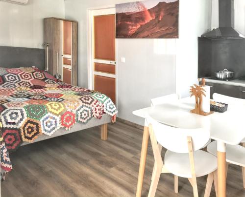 een slaapkamer met een bed en een tafel en stoelen bij Studio avec balcon amenage et wifi a Sainte Suzanne in Sainte-Suzanne