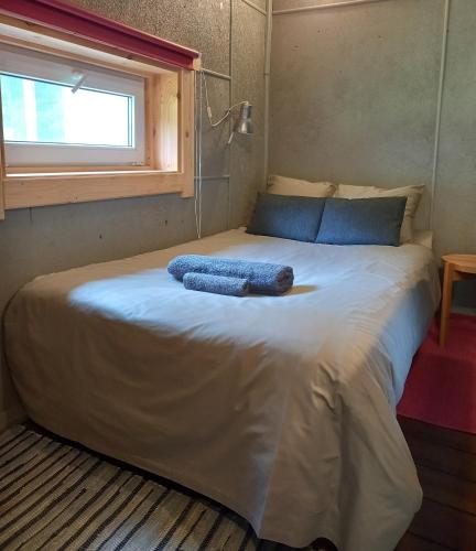 a bed with two blue towels on it in a room at Vastseliina Metskond Camping in Vahtseliina