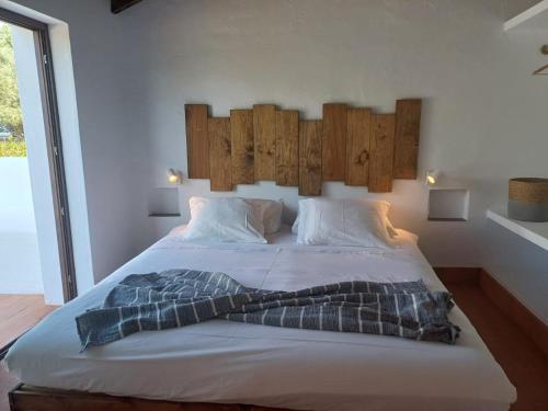 1 dormitorio con 1 cama grande y cabecero de madera en Monte do Serrado De Baixo, en Évora