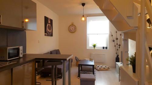Il comprend une cuisine et un salon avec une table et une fenêtre. dans l'établissement Home Appart, à Armentières