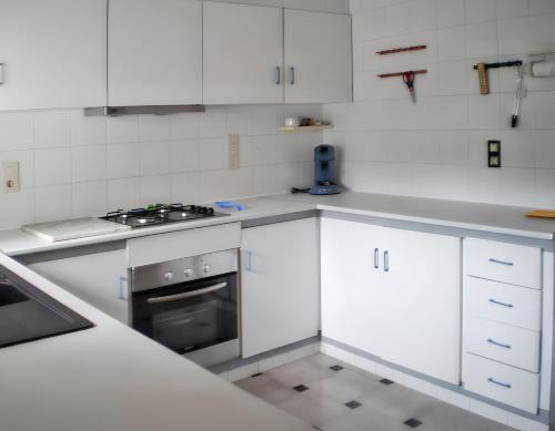 een keuken met witte kasten en een fornuis bij 3 bedrooms villa with private pool and wifi at Benicarlo in Benicarló