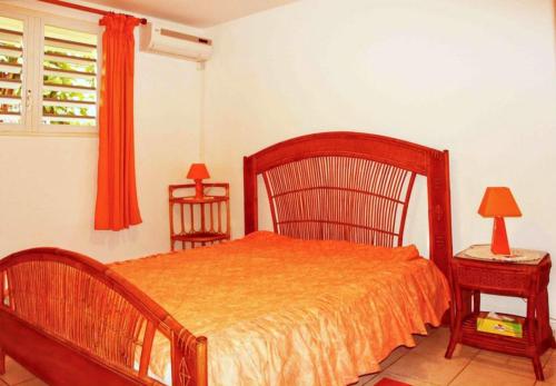 1 dormitorio con 1 cama, 1 silla y 1 ventana en Appartement d'une chambre avec jardin amenage et wifi a Baie Mahault, en Baie-Mahault