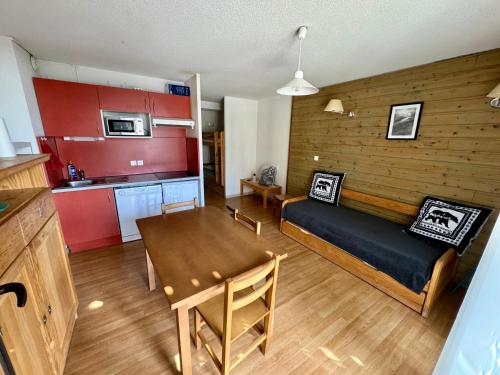 ein Wohnzimmer mit Couch und Tisch und eine Küche in der Unterkunft Joli studio en montagne in Font Romeu Odeillo Via