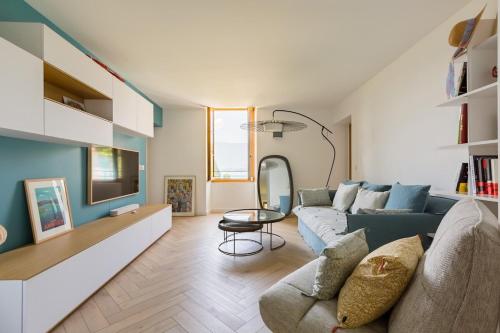 salon z kanapą i stołem w obiekcie Appartement avec Jardin & vue Lac Talloires (15' Annecy) w mieście Talloires