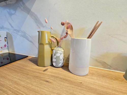 three vases sitting on top of a wooden table at T2 Ctre ville Fibre Literie Emma in Montrichard