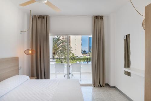a bedroom with a bed and a large window at Sol Lunamar Palmanova Apartamentos - Adults Only in Palmanova