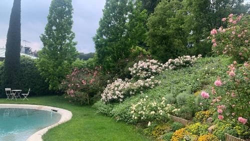 a garden with flowers and a swimming pool at Al vecchio fienile in Fagagna