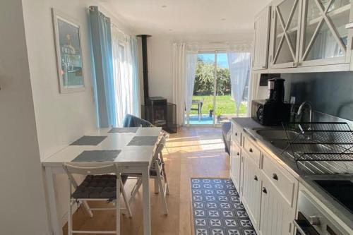 - une cuisine avec une table, des chaises et un comptoir dans l'établissement Côté surf maison ensoleillée à 150m de la plage, à Penmarcʼh