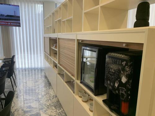een woonkamer met een entertainmentcentrum met een tv bij Areosa in Porto