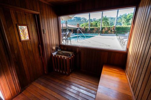 an empty room with a large window in a house at Vale das Orquídeas Pousada in Socorro