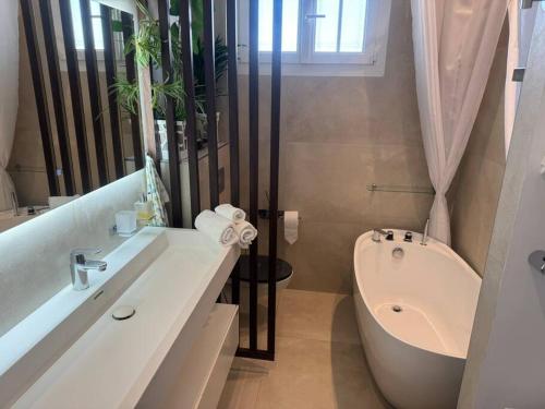 une salle de bain avec une baignoire, des toilettes et un lavabo dans l'établissement Appartement T3 grand standing à Juan Les Pins, à Antibes