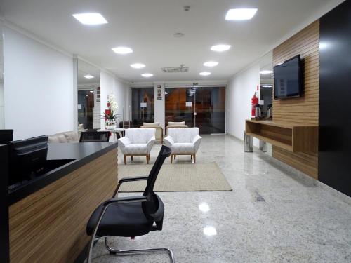 a lobby with chairs and a television in a building at BITTI HOTEL Aracruz by Samba in Aracruz