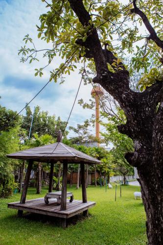 a wooden swing set in a park with a tree at Paragon Inn in Lat Krabang