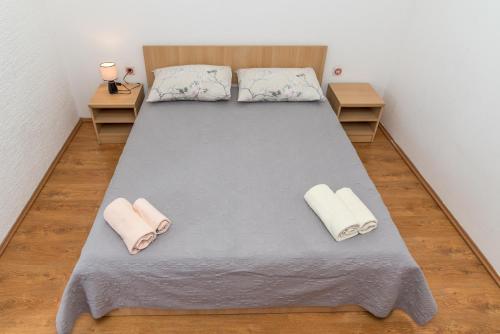 a bed in a room with two pillows on it at Apartmani Danijel in Nin