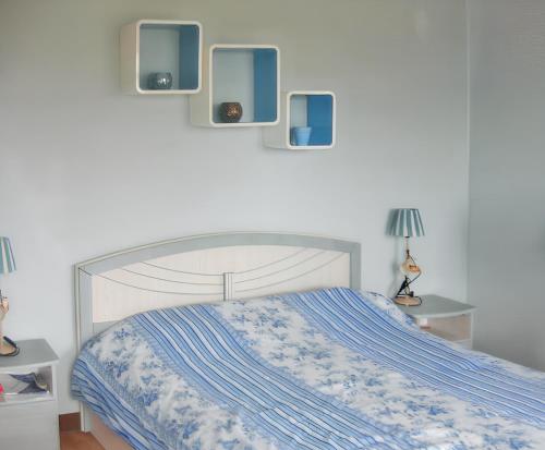 a bedroom with a bed with blue and white sheets at 2 bedrooms apartement at Grand Gaube 200 m away from the beach with sea view furnished terrace and wifi in Grande Gaube